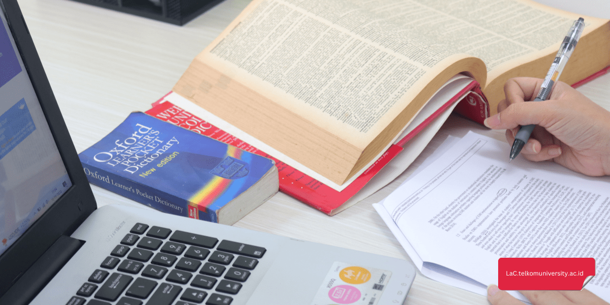 Mahasiswa sedang belajar kosakata bahasa Inggris berdasarkan tema dengan buku dan laptop
