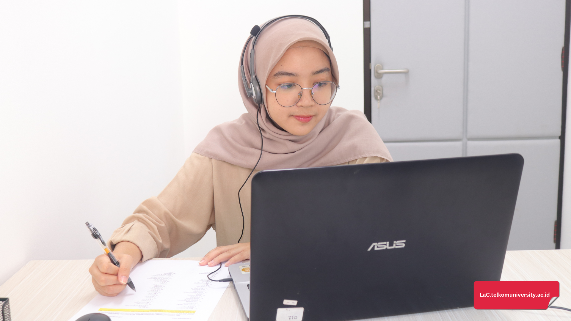 Mahasiswa Telkom University belajar menulis esai Integrated Writing TOEFL iBT dengan laptop.
