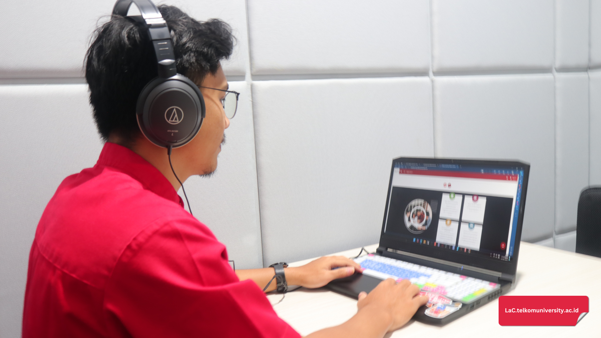 Peserta TOEFL iBT sedang berlatih Integrated Speaking Task menggunakan headset dan komputer di ruang ujian.